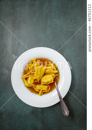 Homemade tortellini in broth in a top view 46781313