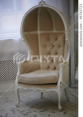 Massive old chair with light fabric upholstery and high closed back 46783723