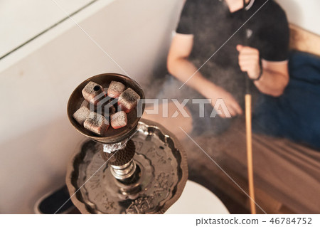 Man smoking hookah 46784752