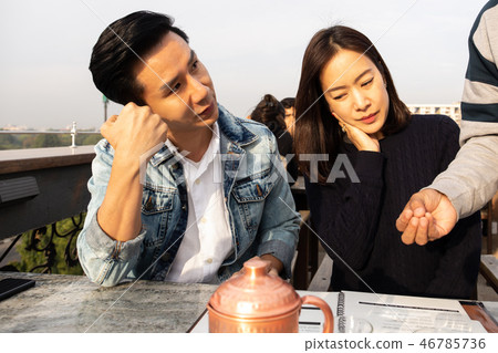 Waiter talking with the couple clients before serving tea and fo 46785736