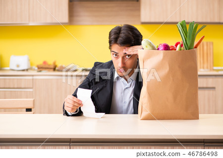 Young handsome man with vegetables in kitchen Young handsome man with vegetables in kitchen 46786498