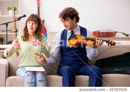 Young woman during music lesson with male teacher Young woman during music lesson with male teacher 46787020