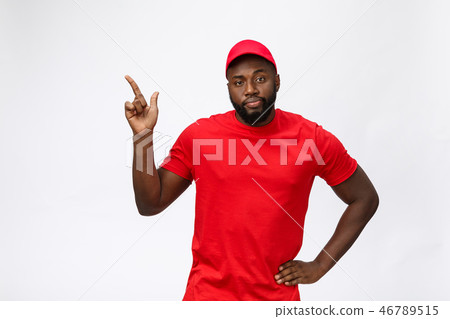Portrait of handsome african american delivery man annoying pointing finger on side. Isolated over Portrait of handsome african american delivery man annoying pointing finger on side. Isolated over 46789515
