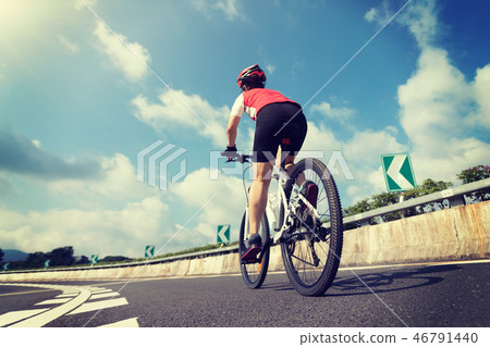 Woman cyclist riding Mountain Bike on highway 46791440