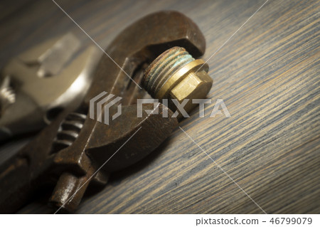 Adjustable wrench on a rustic wood background Adjustable wrench on a rustic wood background 46799079
