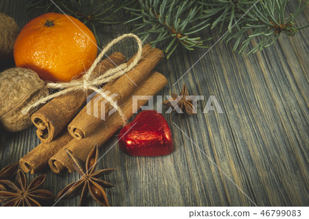 Bunch of cinnamon orange anise next to pine branch 46799083