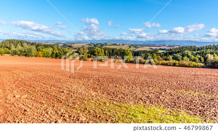 Typical red soil of countryside around Nova Paka. Agricultural Landscape with Giant Mountains on the Typical red soil of countryside around Nova Paka. Agricultural Landscape with Giant Mountains on the 46799867