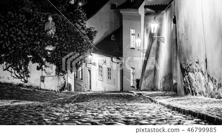 Narrow cobbled street in old medieval town with illuminated houses by vintage street lamps, Novy 46799985