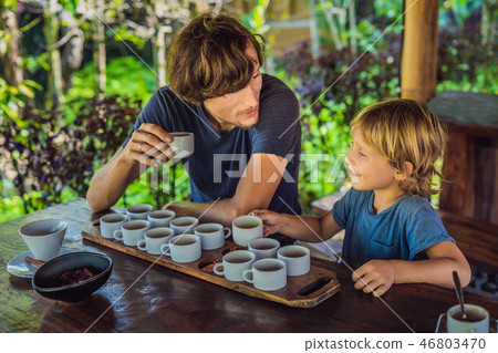 Dad and son are tasting different kinds of coffee and tea, including coffee Luwak 46803470