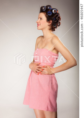 Girl in hair curlers on gray 46805447