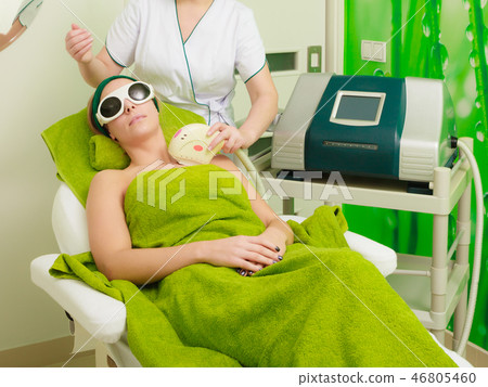 Woman getting laser treatment in beautician Woman getting laser treatment in beautician 46805460