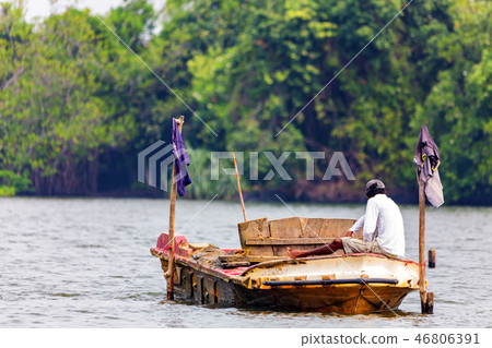 Traditional Sri Lankan fisherman in river back view Traditional Sri Lankan fisherman in river back view 46806391