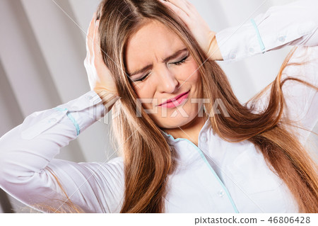 stressed woman in white shirt with headache 46806428