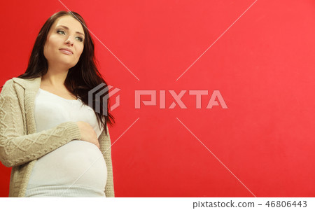 Sitting pregnant woman showing belly Sitting pregnant woman showing belly 46806443
