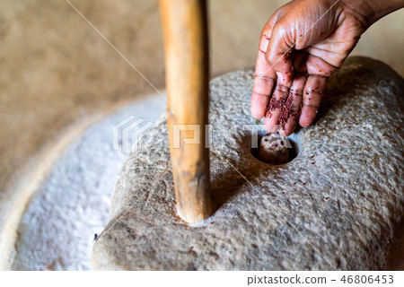 Hands work with millstone to grind sorhum in Sri lankan house Hands work with millstone to grind sorhum in Sri lankan house 46806453