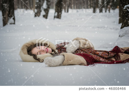 Happy girl lie around in soft snow on a winter day Happy girl lie around in soft snow on a winter day 46808466