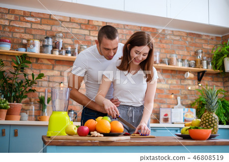 Young couple making smoothie in kitchen Young couple making smoothie in kitchen 46808519