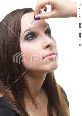 Woman applying eyeshadow makeup brush 46808709