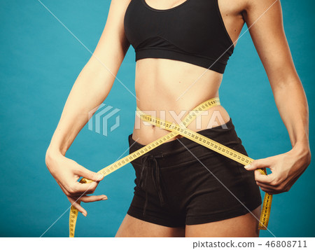 Fitness girl measuring her waistline Fitness girl measuring her waistline 46808711
