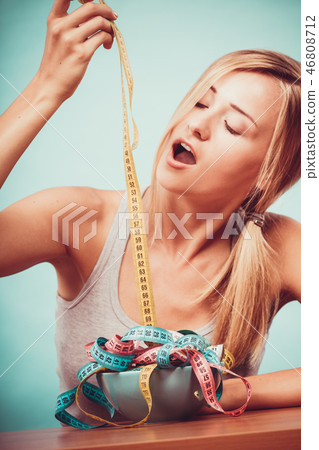 Diet. Girl with colorful measuring tapes in bowl 46808712