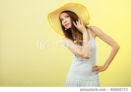 Woman in big yellow summer hat. Woman in big yellow summer hat. 46808715