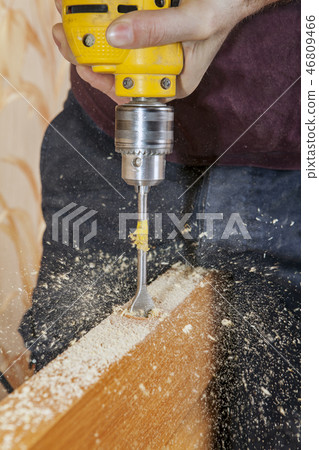 Carpenter drills latch hole of door lock Carpenter drills latch hole of door lock 46809466
