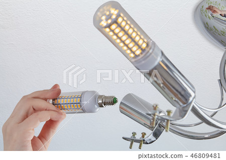setting LED corn lamp into chandelier in room 46809481