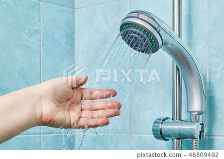 Water falls on palm, splashing in all directions. 46809492