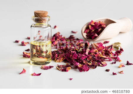 A bottle of rose essential oil with dried petals A bottle of rose essential oil with dried petals 46810780