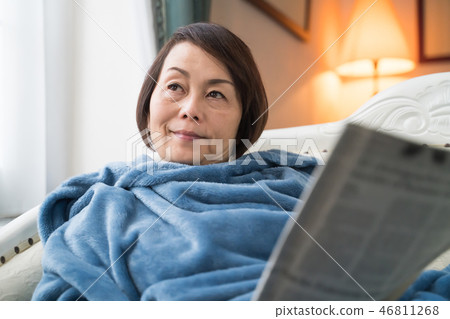 A woman reading a newspaper A woman reading a newspaper 46811268