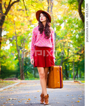 brunet girl with suitcase in the park. brunet girl with suitcase in the park. 46812294