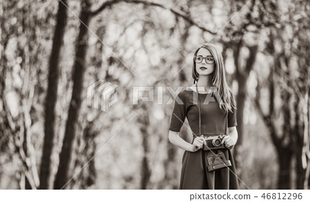 woman with vintage camera in a park in spring time woman with vintage camera in a park in spring time 46812296
