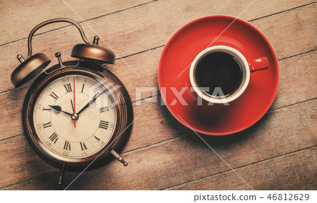 classic alarm clock and red cup of a coffee classic alarm clock and red cup of a coffee 46812629