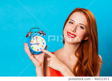 Smiling redhead woman woth alarm clock Smiling redhead woman woth alarm clock 46812951