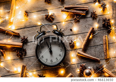 alarm clock and cinnamon, star anise with Christmas lights alarm clock and cinnamon, star anise with Christmas lights 46813650