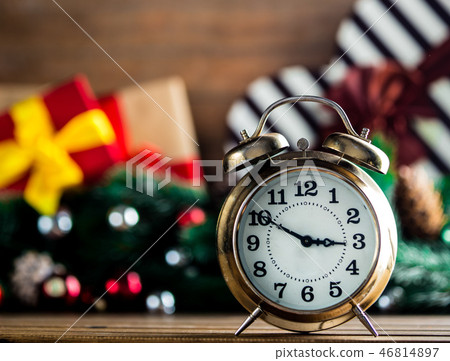 Alarm clock on wooden table with Christmas gifts Alarm clock on wooden table with Christmas gifts 46814897