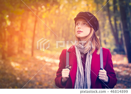 woman in red coat and backpack have a rest in autum park woman in red coat and backpack have a rest in autum park 46814899