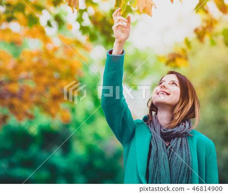 woman holding yellow maple tree leaf in autum park woman holding yellow maple tree leaf in autum park 46814900