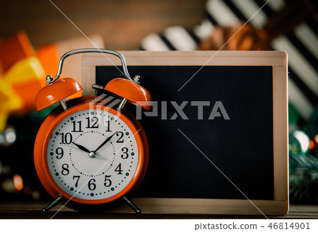 Alarm clock and blackboard on wooden table 46814901