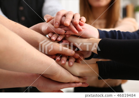 Group of people in suits crossed hands in pile for win Group of people in suits crossed hands in pile for win 46819484