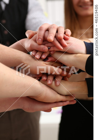 Group of people in suits crossed hands in pile for win Group of people in suits crossed hands in pile for win 46819486
