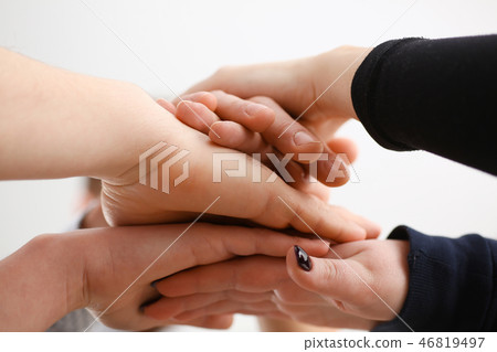 Group of people in suits crossed hands in pile for win Group of people in suits crossed hands in pile for win 46819497