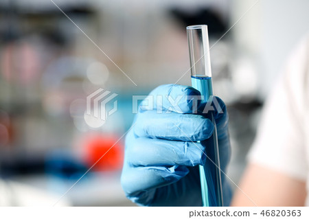 A male chemist holds test tube of glass 46820363