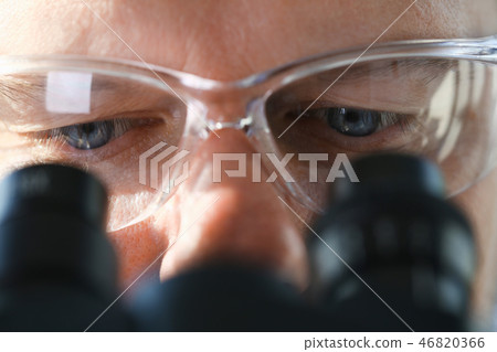 Male scientist looking through binocular Male scientist looking through binocular 46820366