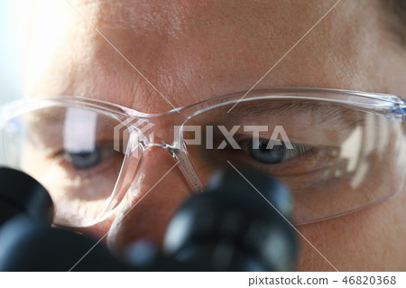 Male scientist looking through binocular Male scientist looking through binocular 46820368