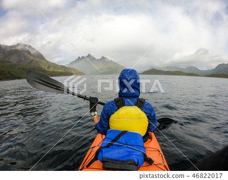 Photo from back of tourist with paddle on canoe floating Photo from back of tourist with paddle on canoe floating 46822017