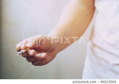 The man smoking a cigarette in hand. Cigarette  46823008