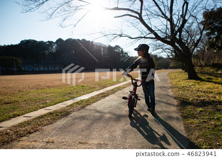 A girl playing with a bicycle 46823941