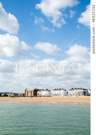 英國郊外的海邊街道白色的牆壁和紅褐色的建築物沿著海岸線排列 46825192