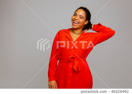 Positive delighted young woman touching her hair Positive delighted young woman touching her hair 46826992